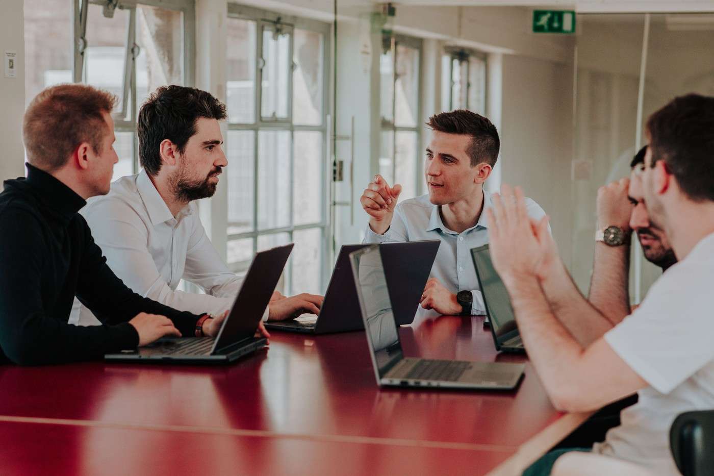 L'équipe de Scopt en discussion autour d'une table avec des ordinateurs portables