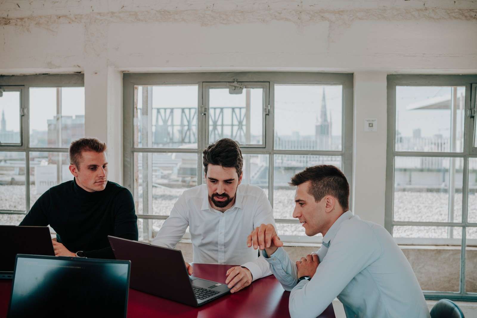 Trois membres de l'équipe Scopt au travail autour d'une table dans le bureau de Louvain